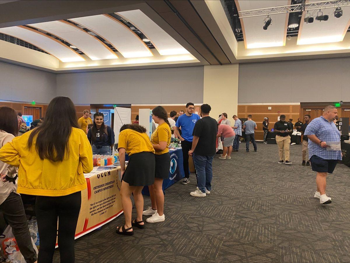 Some students stop at the Orthodox Christian Campus Ministries table. (Photo by Alyssa Williams)