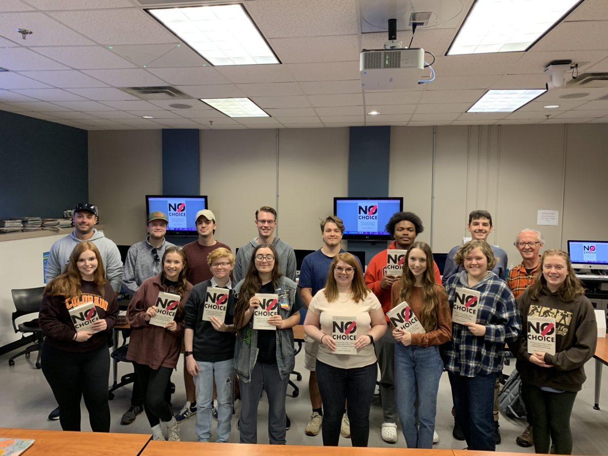 Becca Andrews (front row, fourth from right) stands with a Middle Tennessee State University reporting class with copies of her book, "No Choice." (Photo by MTSU Sidelines staff photographer)