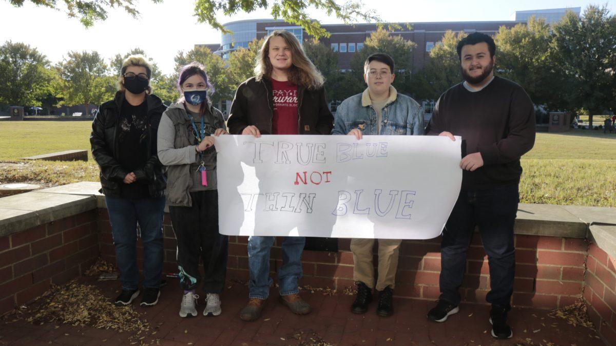 Left to right - Kim Bogdanopic, Ty Stallings, Tyler Roadman, Theo Baker andRavel Pirouznia, holding their sign, “True Blue Not Thin Blue” in front of the Student Union. (Photo by Aubrey Salm)