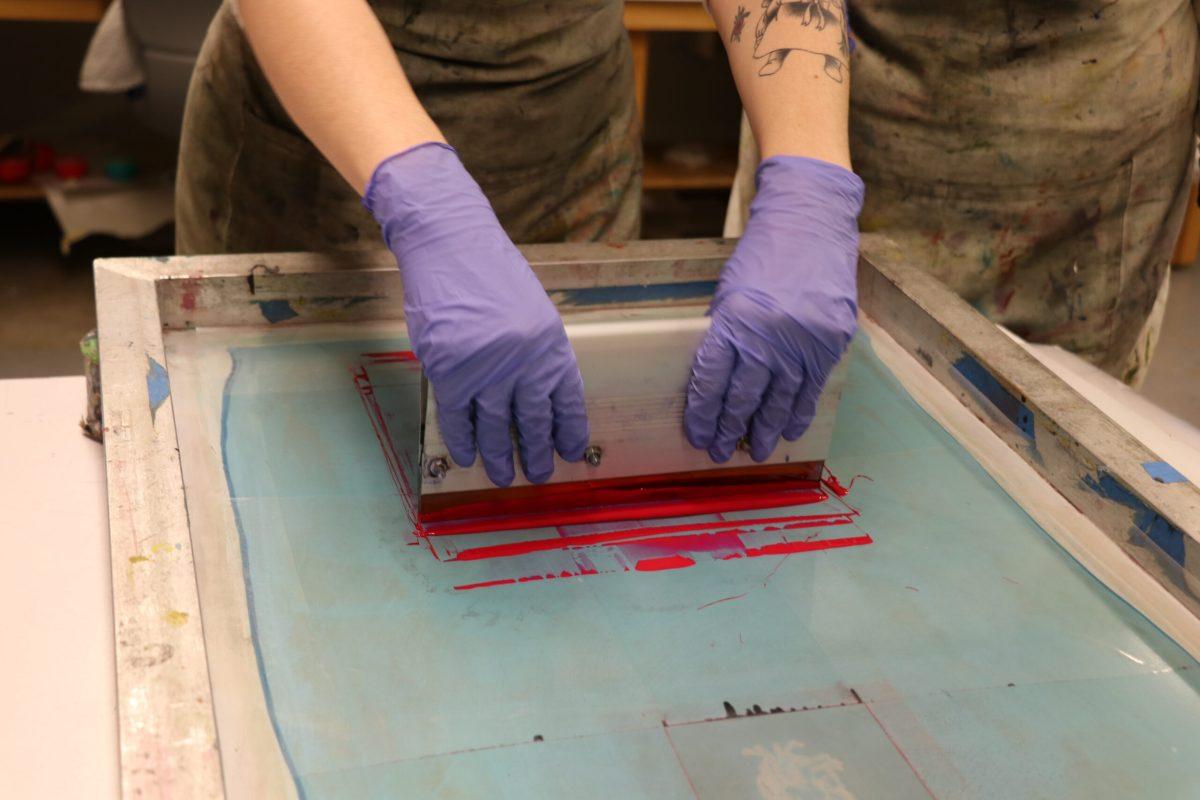 Club President Messler instructing students on print making.
(Photo by Kaleigh Young). 