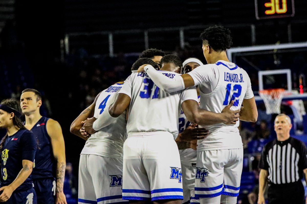 The MTSU men's basketball team huddles together. (Photo by Luke Larkin)