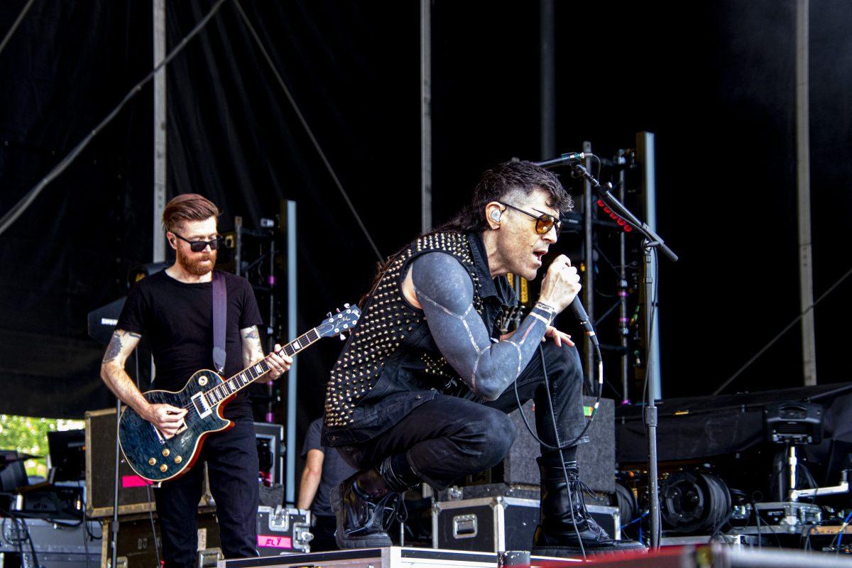 AFI vocalist Davey Havok bends to the audience as he sings to an appreciative audience at Bonnaroo’s What Stage on June 16, 2023. Guitarist Jade Puget is in the background.