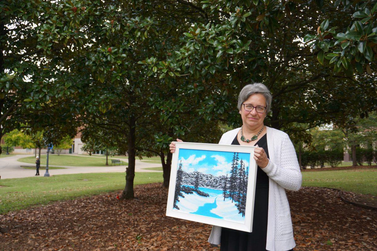 MTSU history professor Amy Sayward holds her friend Farris Morris' painting. Morris is an inmate on death row. Photo by Kailee Shores