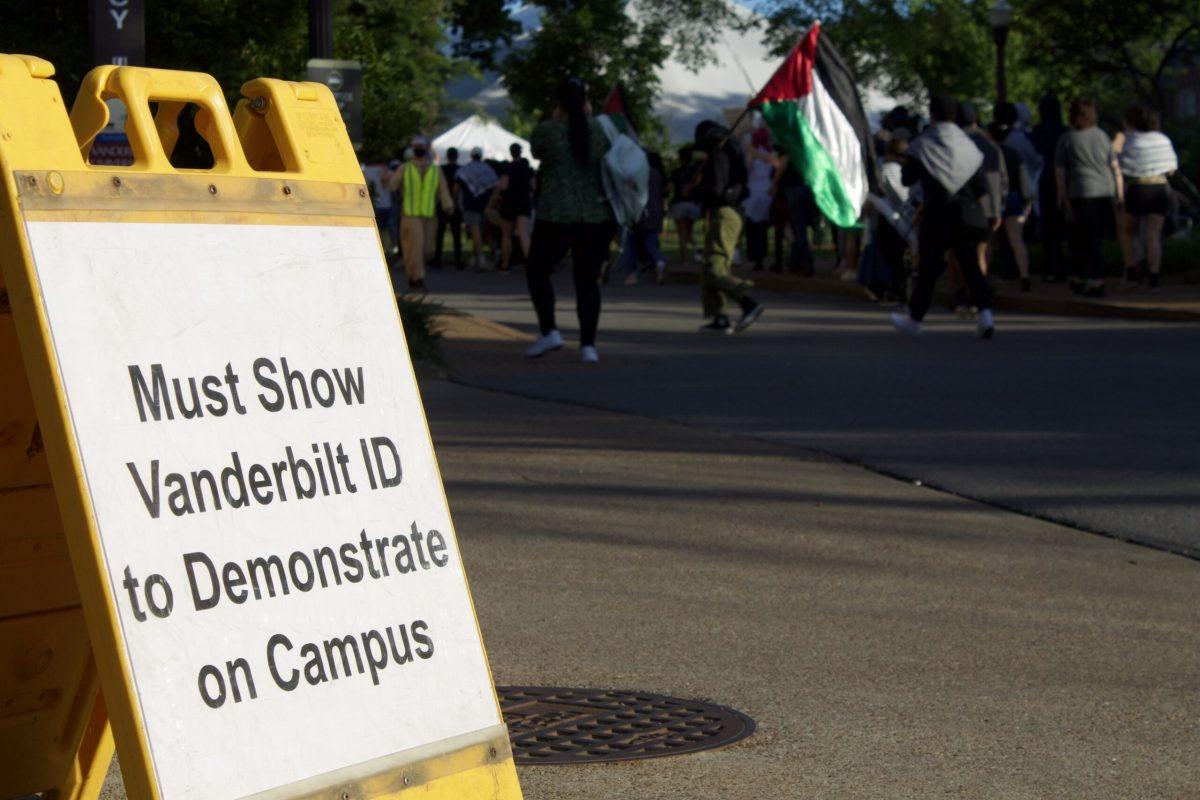 Protestors march past a sign at the entrance of campus that reads “Must show Vanderbilt ID to demonstrate on campus,” however, this policy was not enforced on the crowd. (Taken by Noah McLane)