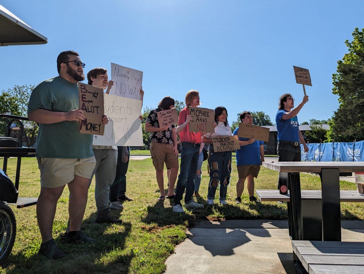 About a dozen protesters stood at a distance from the ceremony, holding signs and briefly chanting. (Taken by Ethan Schmidt)