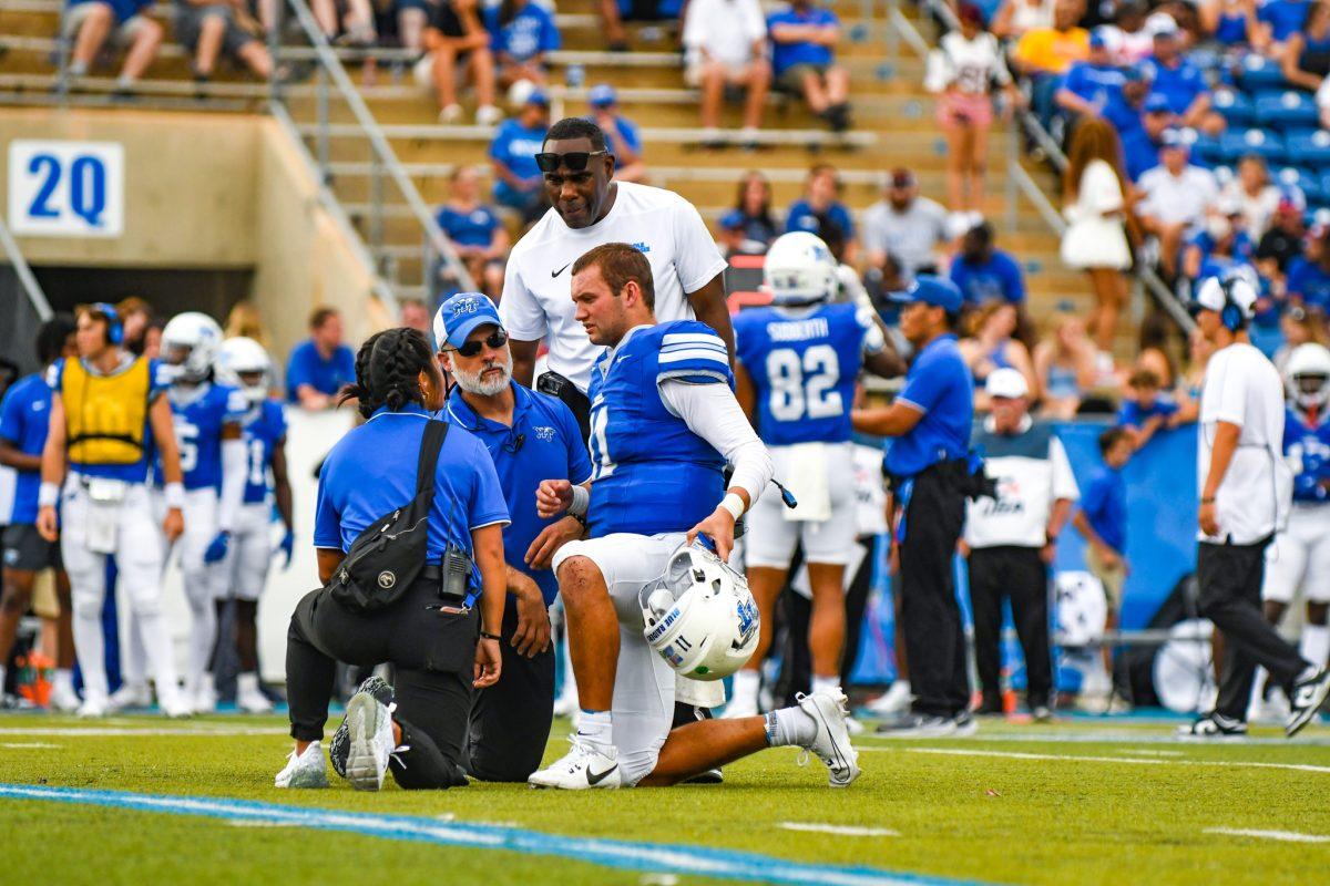 Nick Vattiato on a knee with training staff, 9-21-2024. (Photo by Erin Douglas)