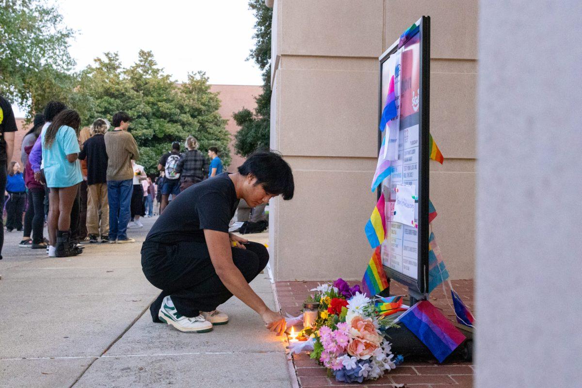 A student lights a candle at a vigil for Serenity Birdsong at MTSU on Oct. 30, 2024. (Photo by Sam McIntyre)