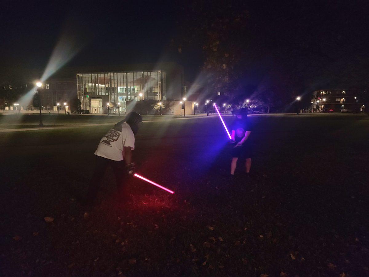 Alijah Jenkins (left, red saber) spars against J.P. Daigle (right, purple saber) at MTSU on Nov. 6, 2024. (Photo by Zavian Hailey.)