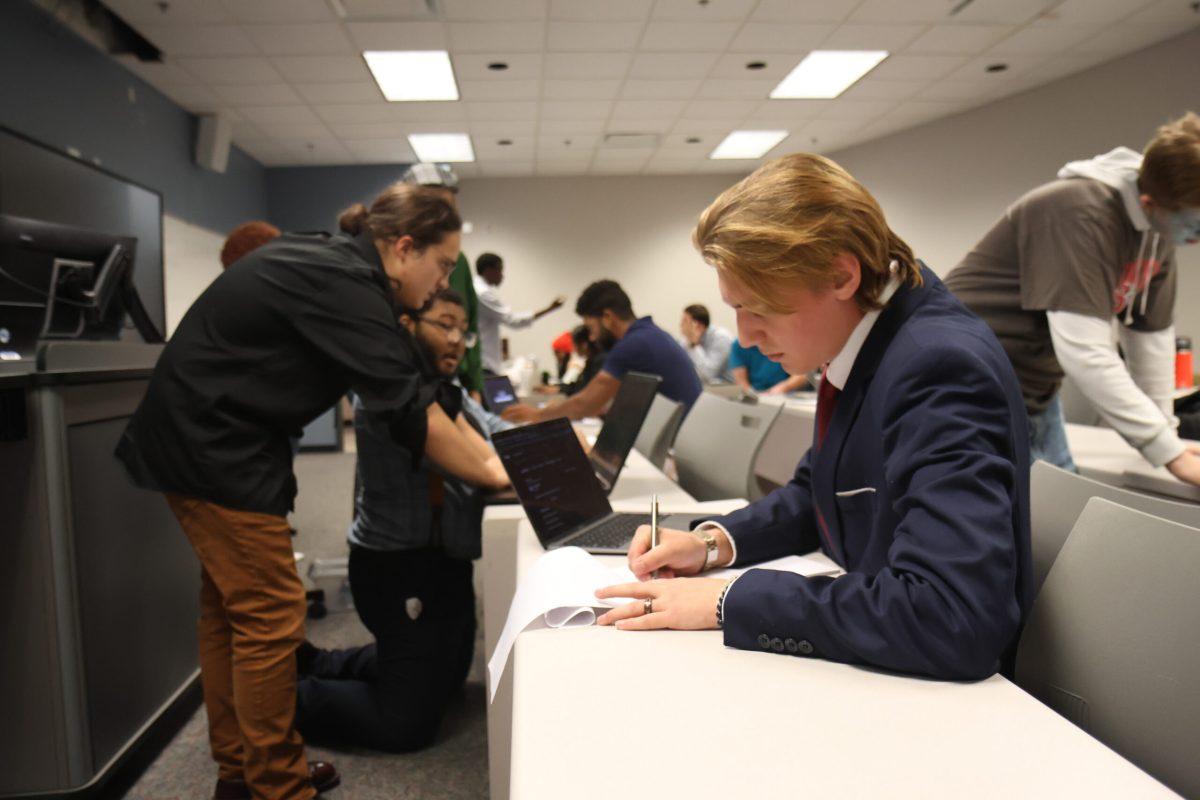 Adriel Davis prepares for a debate in MTSU's prep room, surrounded by other students researching their debate topics and pitching ideas. (Photo by Noah McLane)