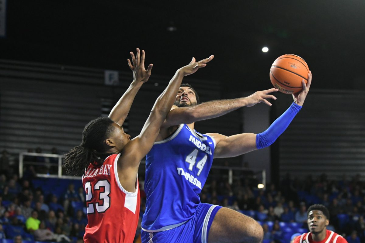 Essam Mostafa (44) shoots a layup around Enoch Kalambay (23) in the Murphy Center on Jan. 18, 2025.