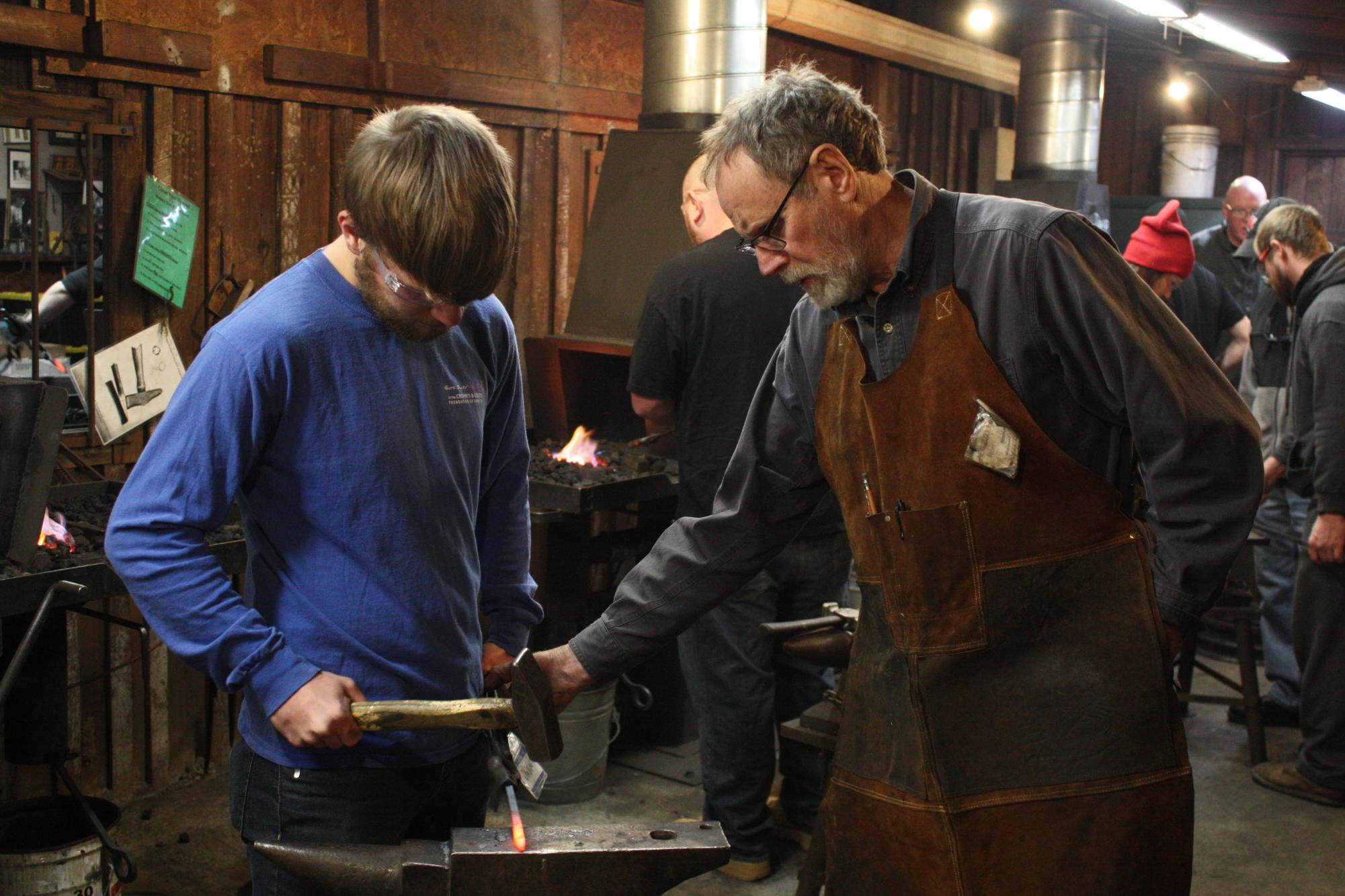 Blacksmithing instructor Ron Nichols guides a student in Murfreesboro, Tennessee, on Jan. 16, 2025.