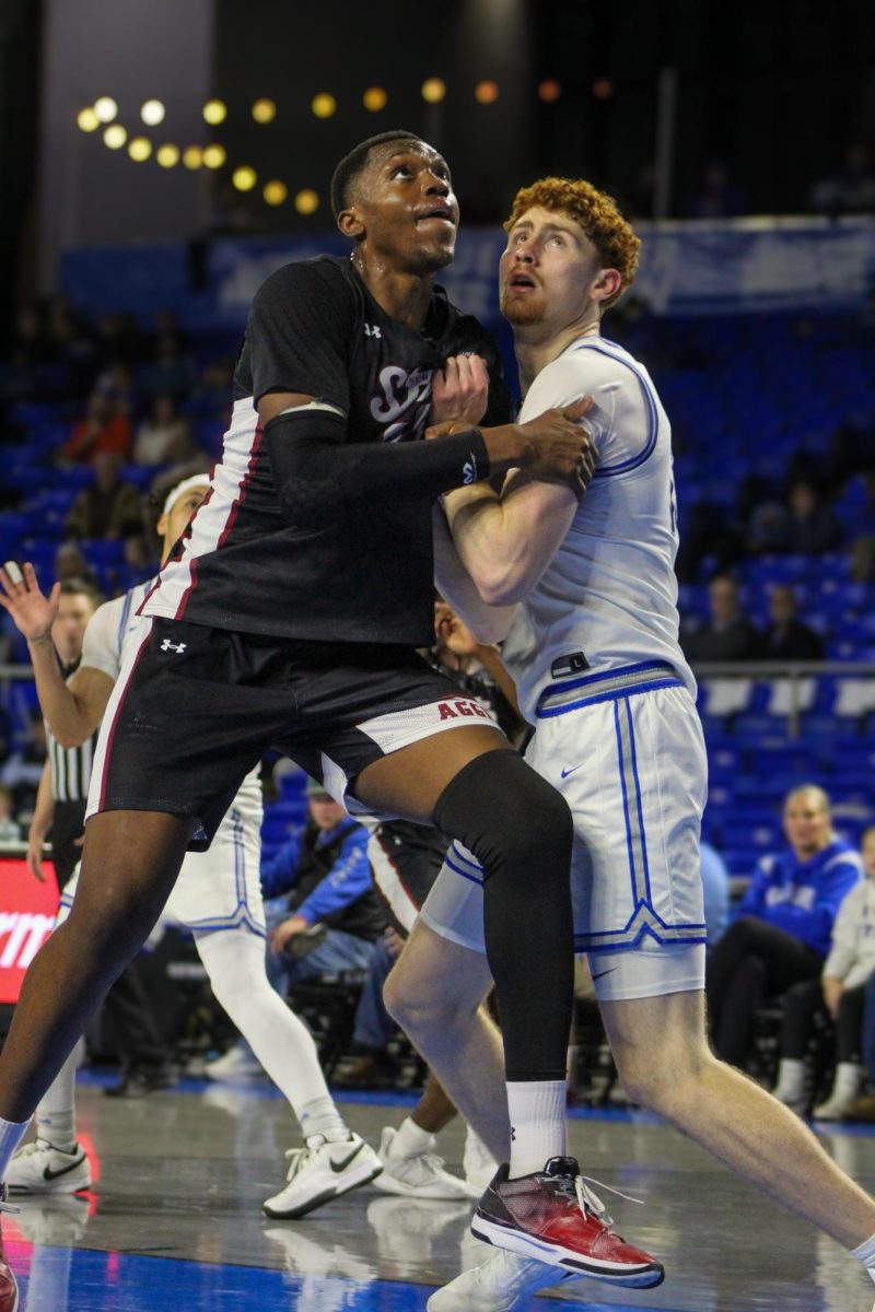 Chris Loofe (right) battles Emmanuel Tshimanga (left) of New Mexico State for a rebound in the Murphy Center on Jan. 30, 2025.