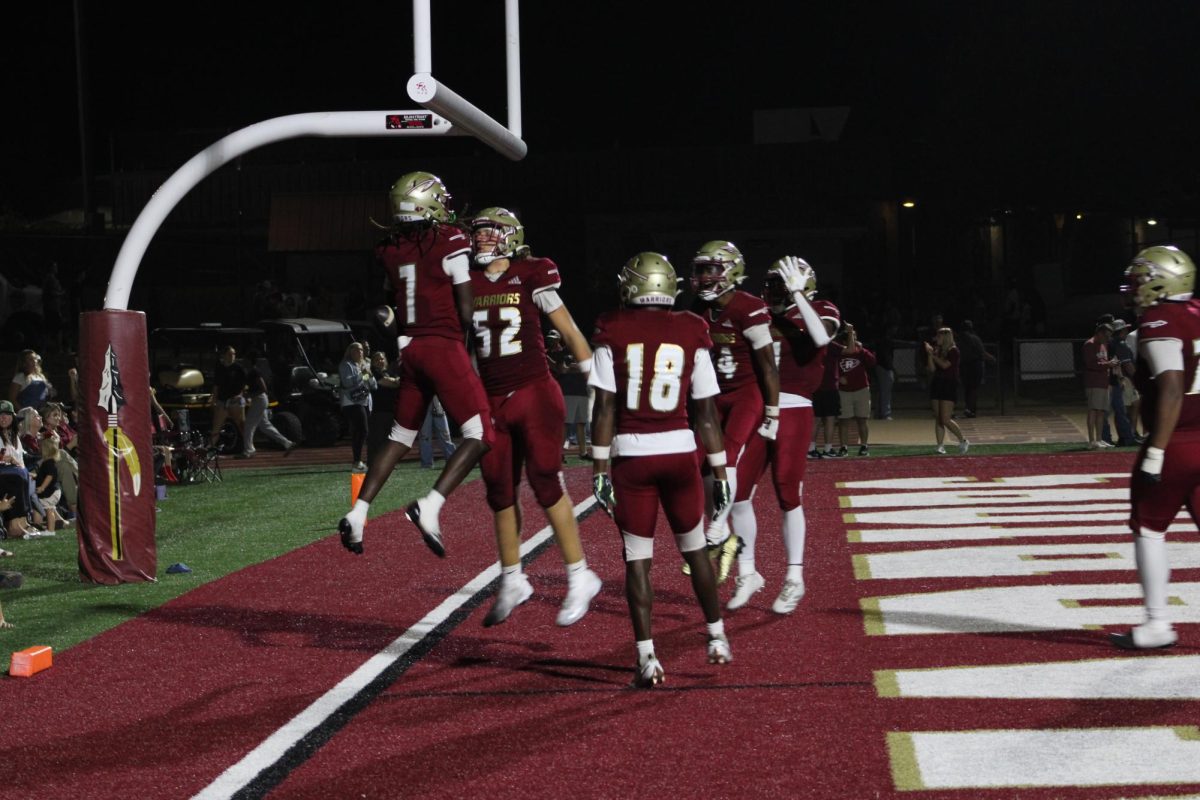 A group of Warriors celebrate in the endzone after a score in Tomahawk Stadium on Aug. 29, 2025.