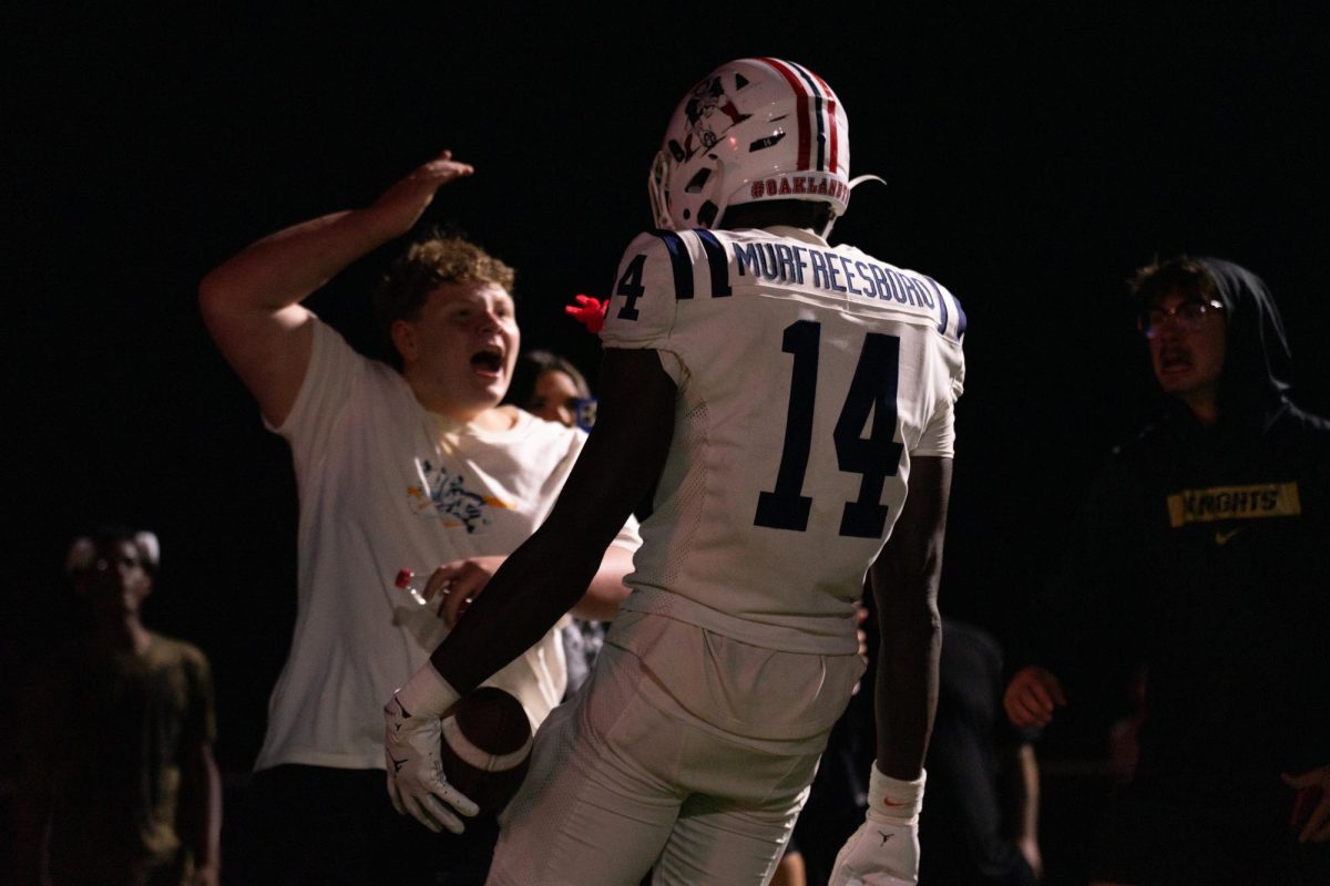 Oakland High School's Joel Wyatt celebrates with a fan after a touchdown against Blackman High School, in Murfreesboro, Tennessee, at Bart Smith Field on Sept. 26, 2025.