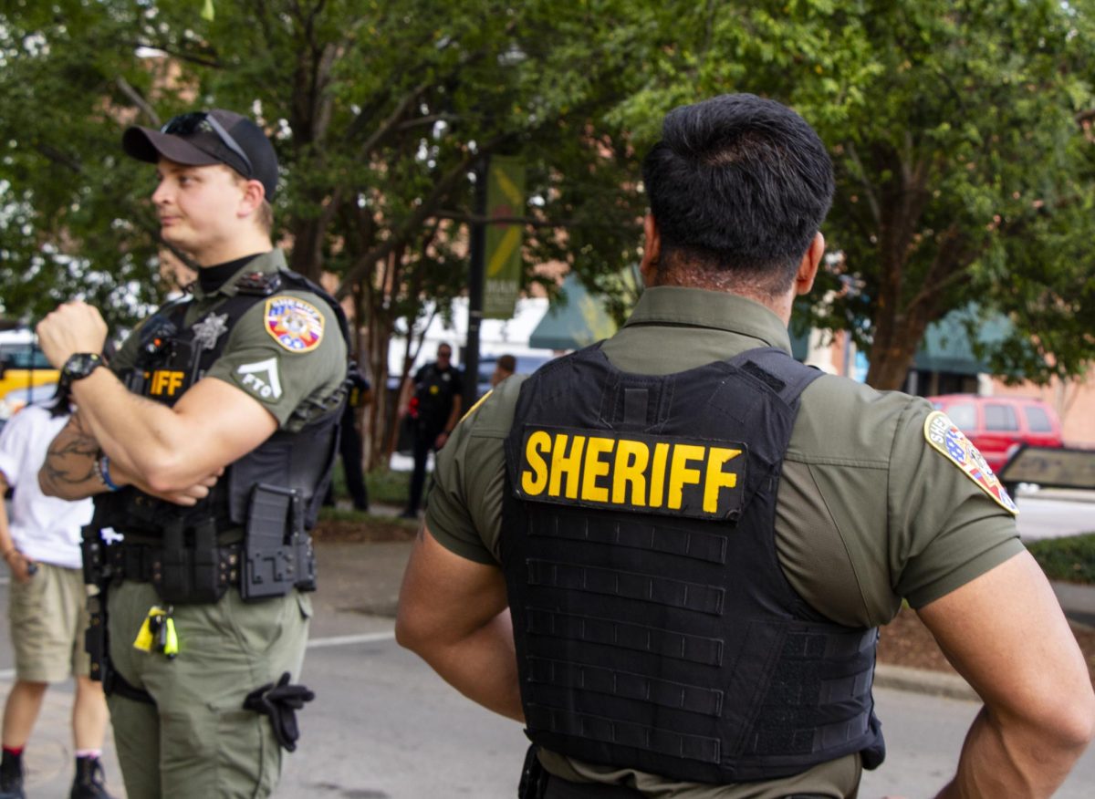 Two Sheriff's deputies stand watch about 20 yards away from the protestors, who had gathered on the courthouse lawn. Police presence was heavy during the Sept. 11 protest against Immigration and Customs Enforcement operations in the county.