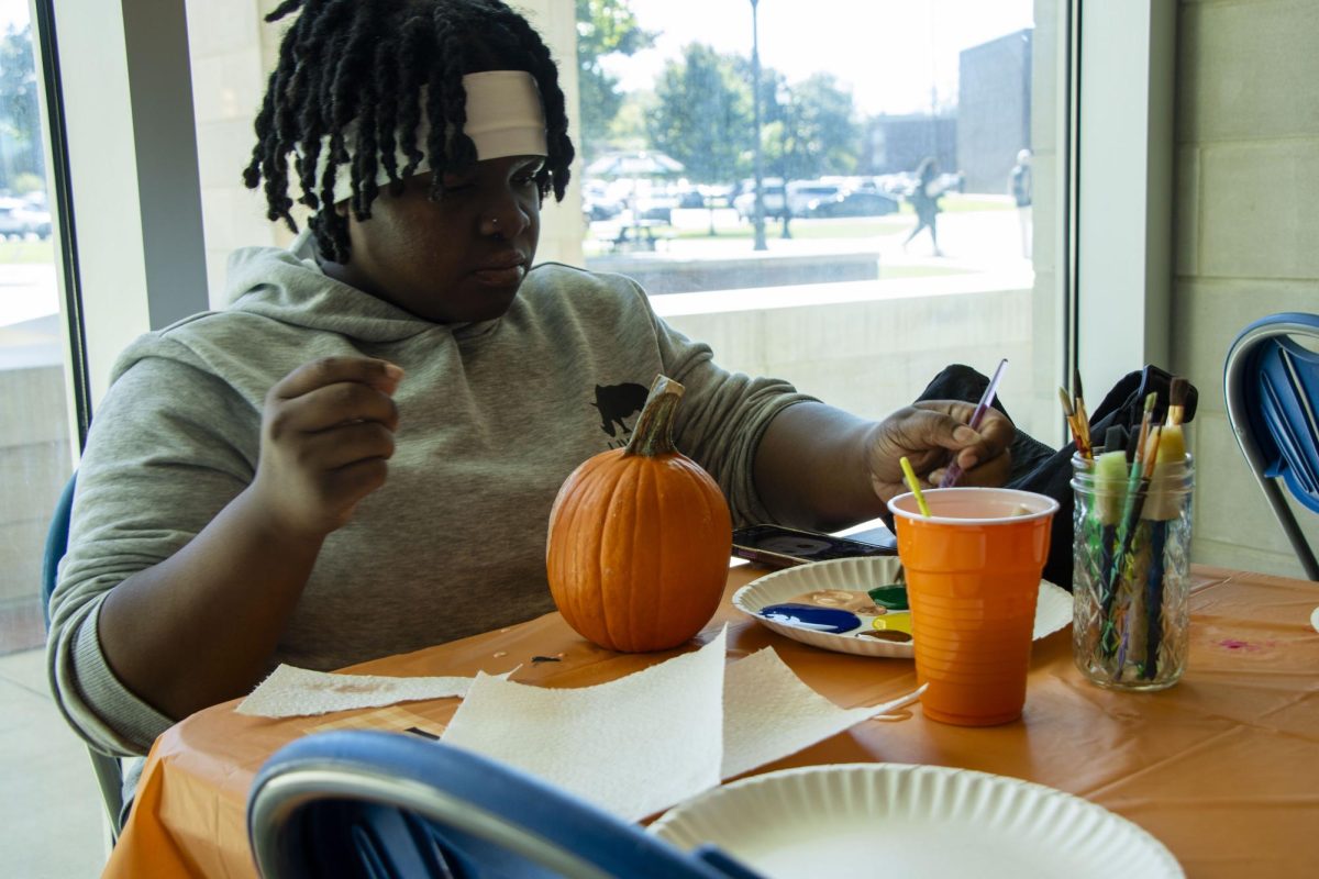 Kennedy Lewis, a sophomore, prepares her paint during the College of Education's pumpkin painting event on Oct. 22, 2025, in the COE foyer.