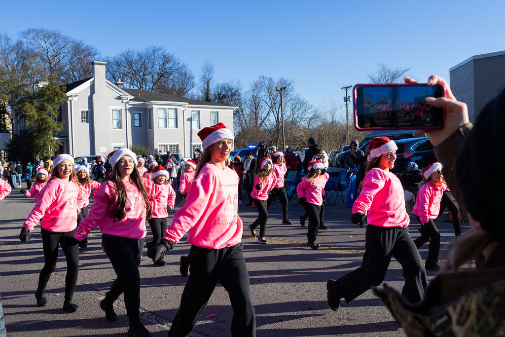 The Dance Academy members dance as they are recorded by supporting parade goers during the Murfreesboro Christmas Parade on E Main St. on Dec. 14, 2025