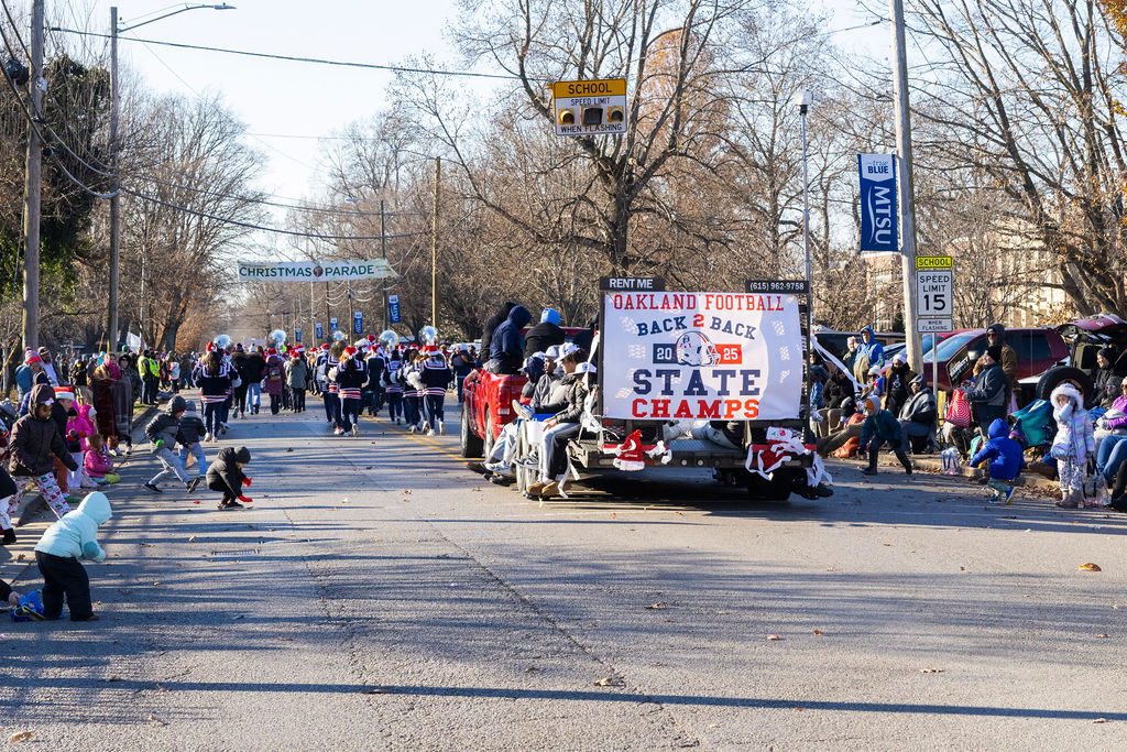 Oakland Football float rolls on outside Central Magnet School as kids pickup candy in the Murfreesboro Christmas Parade on E Main St. on Dec. 14, 2025