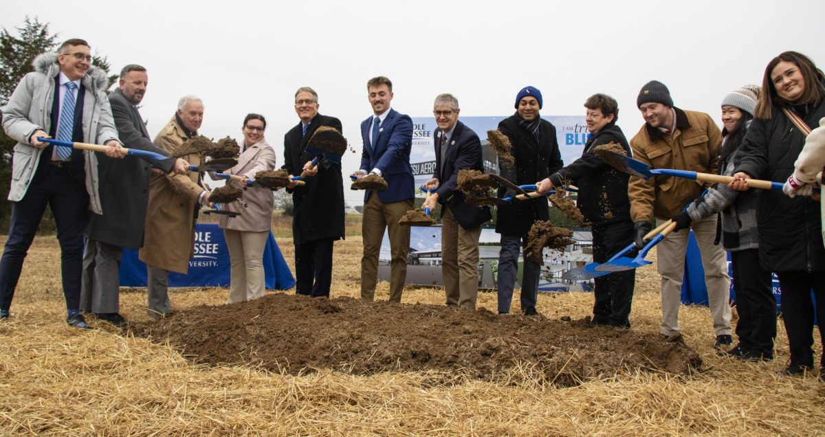 Students and MTSU faculty cross countryremoniously throw dirt at the Shelbyville Municipal Airport on Dec. 2, 2025.