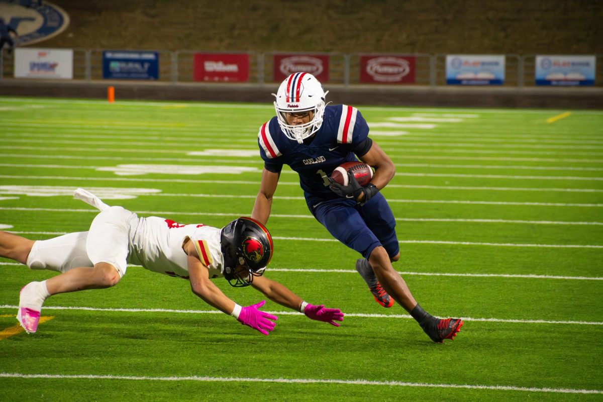 Oakland High School's Craig Tutt avoids a tackle by a Ravenwood High School defender during the BlueCross Bowl at Finley Stadium in Chattanooga, Tennessee, on Dec. 6, 2025.