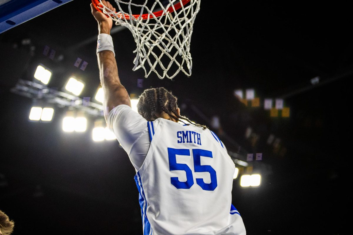 MTSU's Sean Smith hangs on the rim after a dunk against Belmont, in the Murphy Center on Dec. 7, 2025.