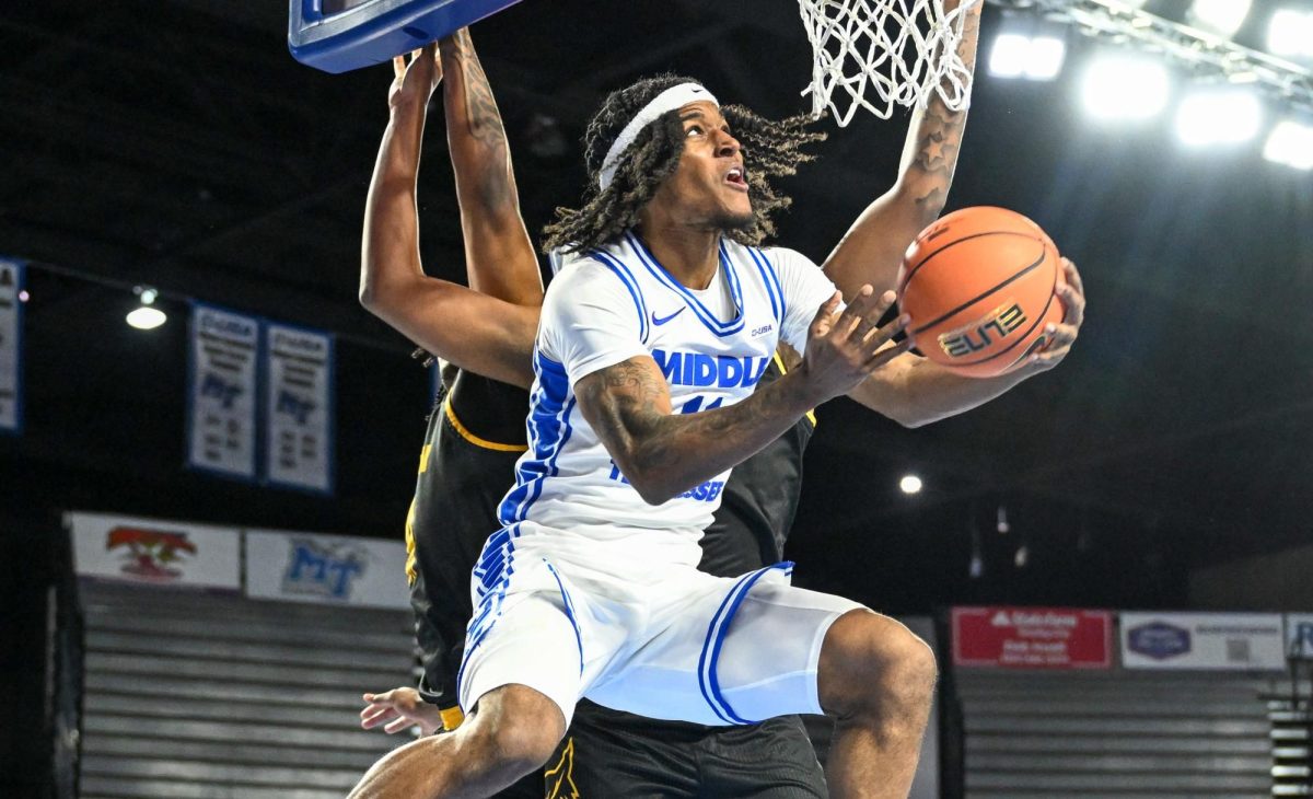 MTSU guard Tre Green hangs in the air to finish at the rim against Kennesaw State in the Murphy Center on Dec. 17, 2025. 