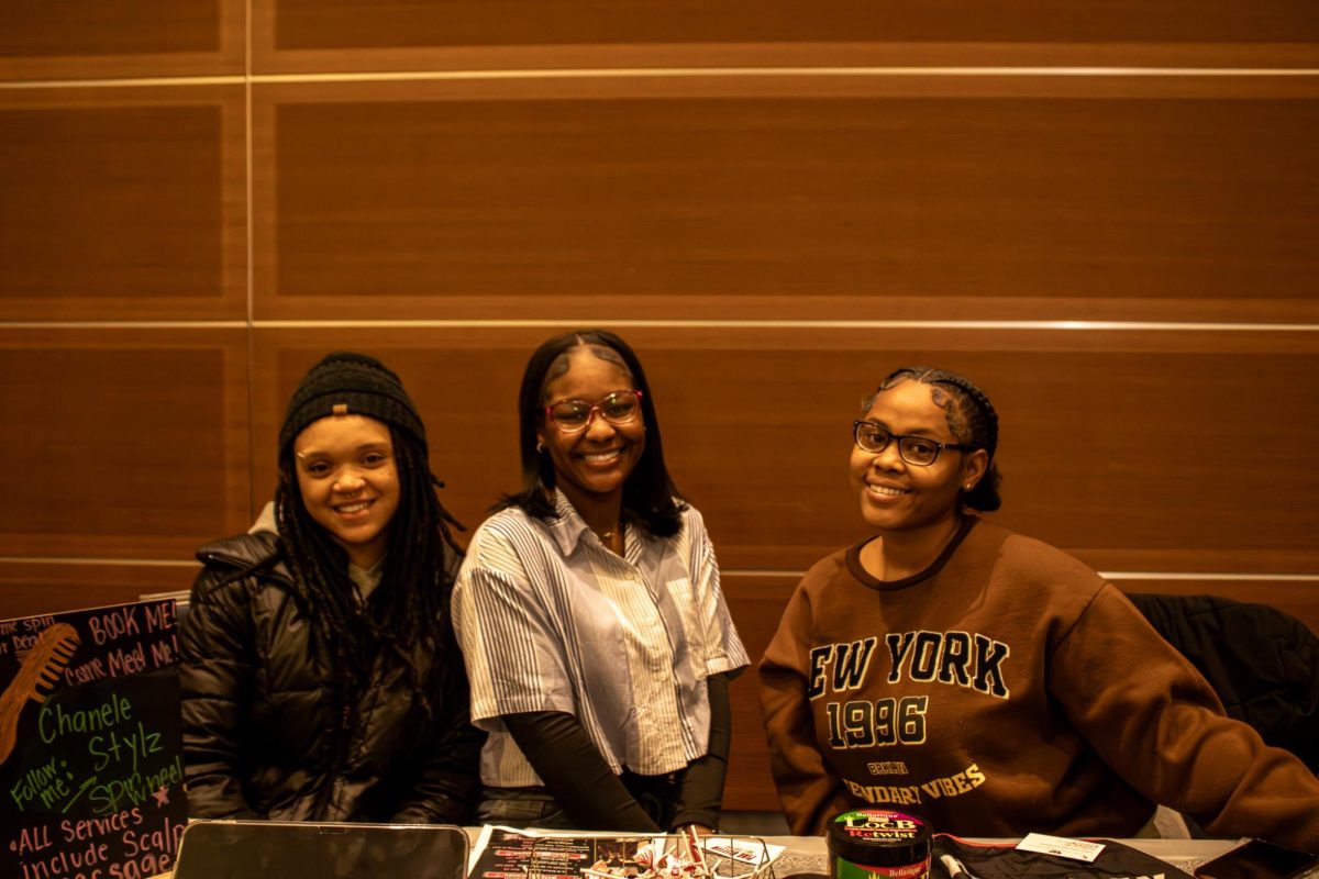 TT Mcalpin, Karma Fugate, and Jayla Shay sit behind the table promoting their hair business at the Black Culture Showcase at MTSU on Feb. 23, 2026.