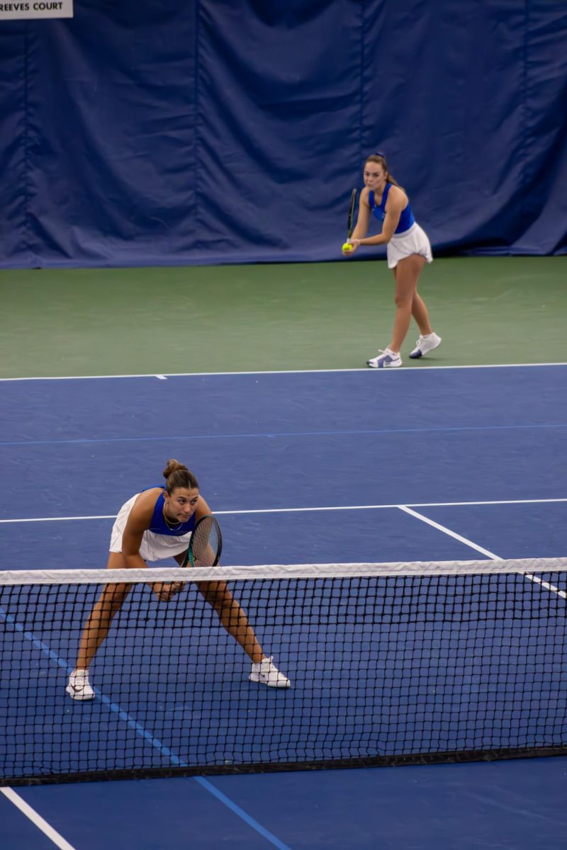 Lena Peyer starts her serve with doubles partner Sara Conde set at the net at the Adams Tennis Complex on Jan. 31, 2026. 