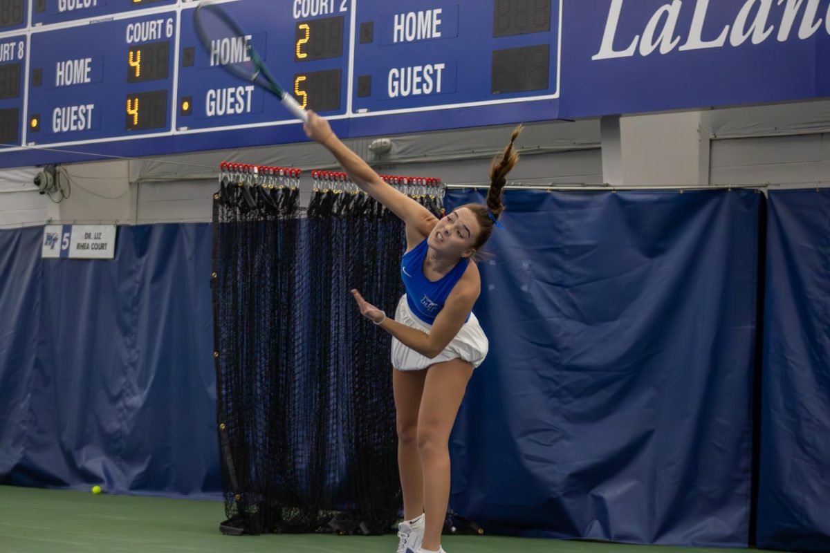 Lena Peyer at the top of her serve against Northwestern University at the Adams Tennis Complex on Jan. 31, 2026. 