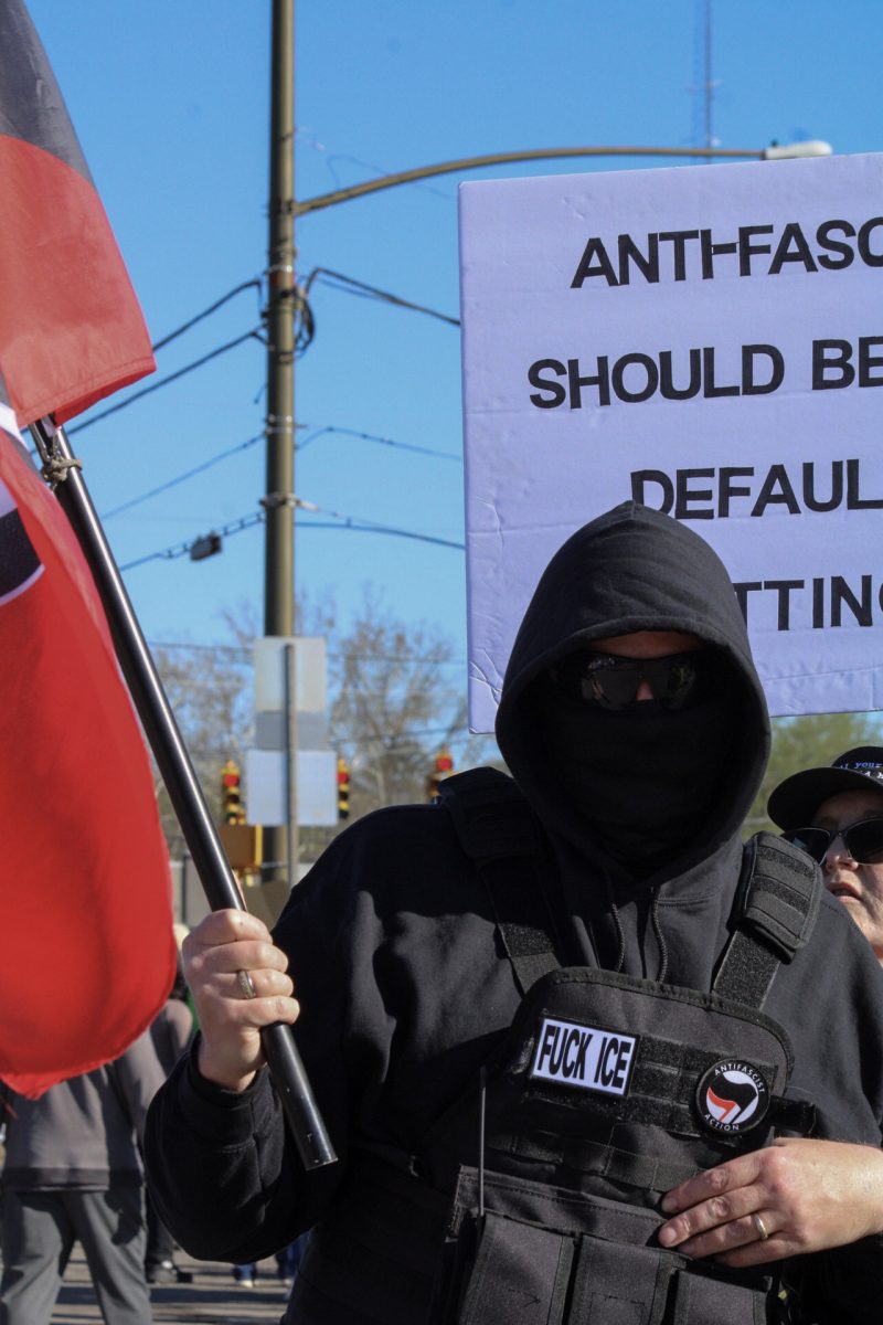 Protester walks along Broad Street in a vest opposing ICE at the "No Kings" protest in Murfreesboro, Tennessee, on March 28, 2026.