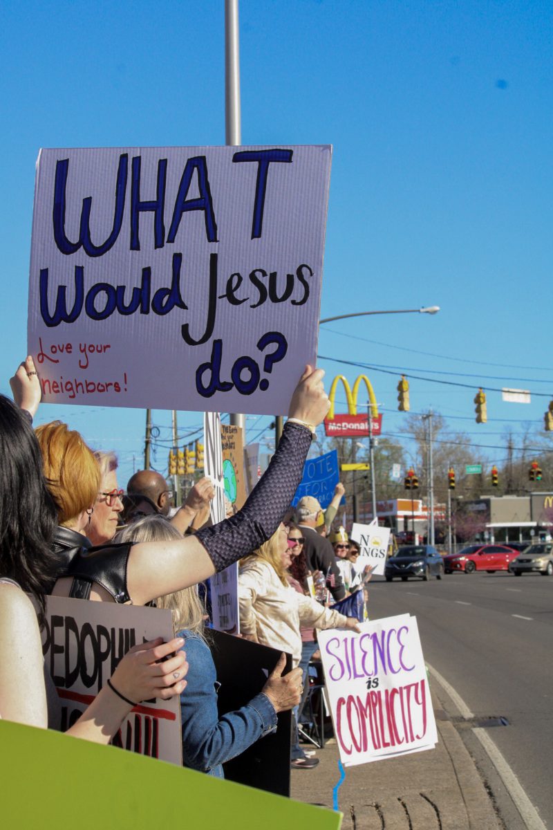 Protesters hold up signs along Broad Street at the "No Kings" protest in Murfreesboro, Tennessee, on March 28, 2026.