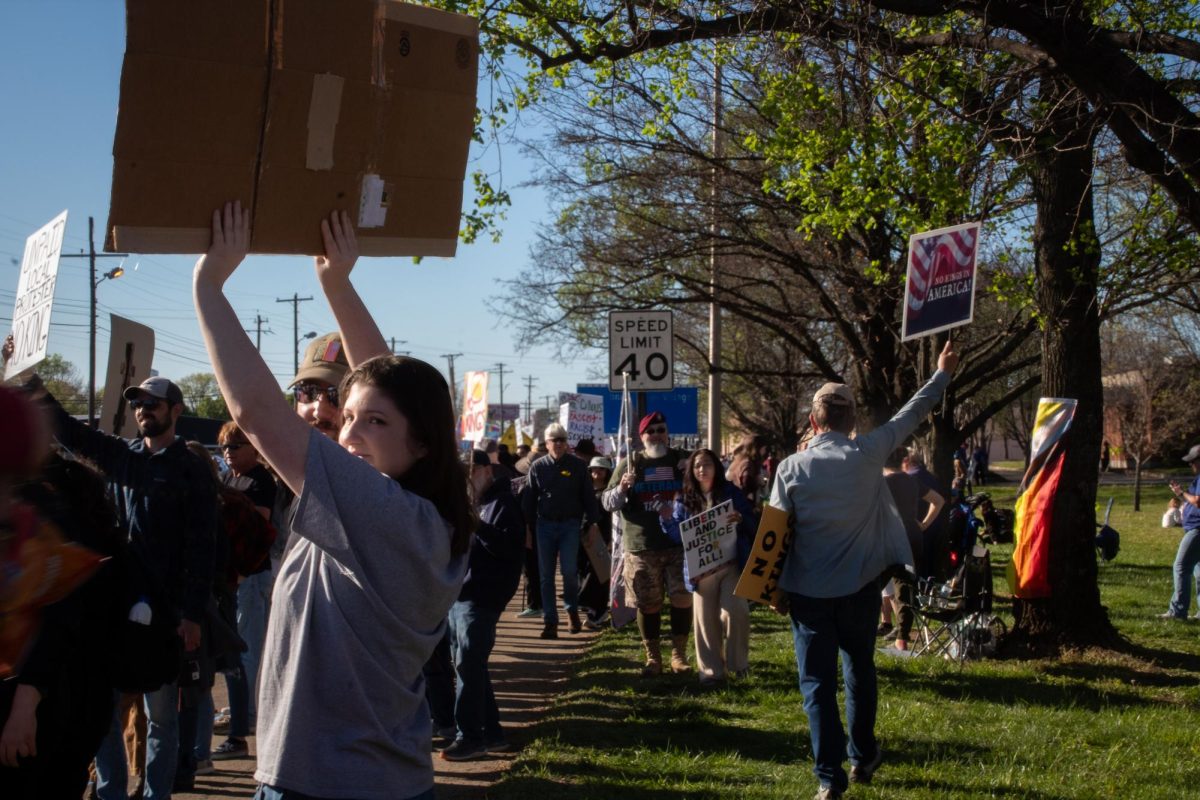Protestors hold signs and walk along Broad Street during a "No Kings" protest in Murfreesboro, Tennessee, on March 28, 2026.