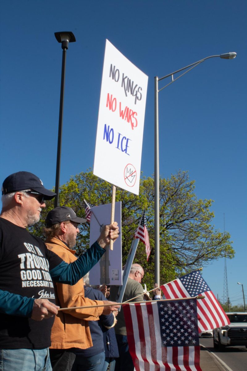 A protester holds a sign that reads "No Kings / No Wars / No ICE" at a "No Kings" protest in Murfreesboro, Tennessee, on March 28, 2026.