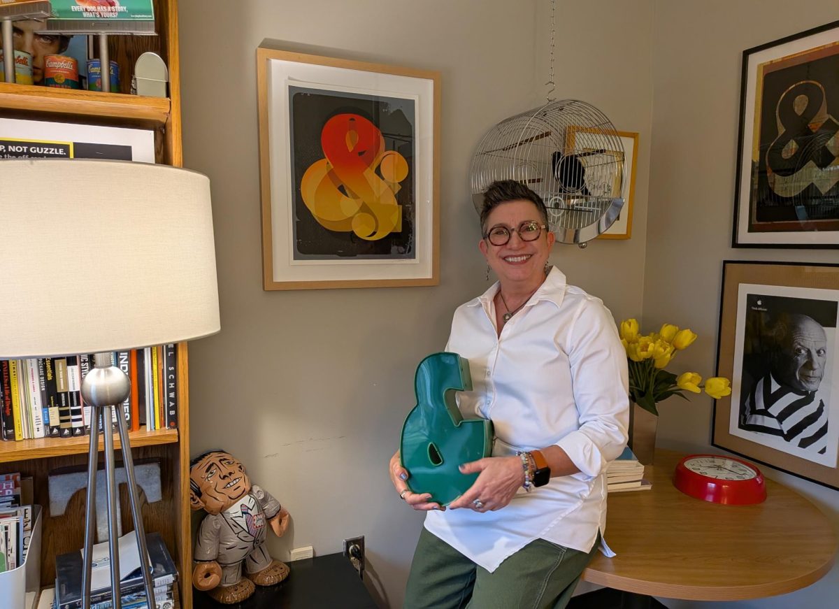 Professor Leslie Haines poses with her beloved ampersand statue, inside the Bragg Media and Entertainment Building on March 26, 2026.
