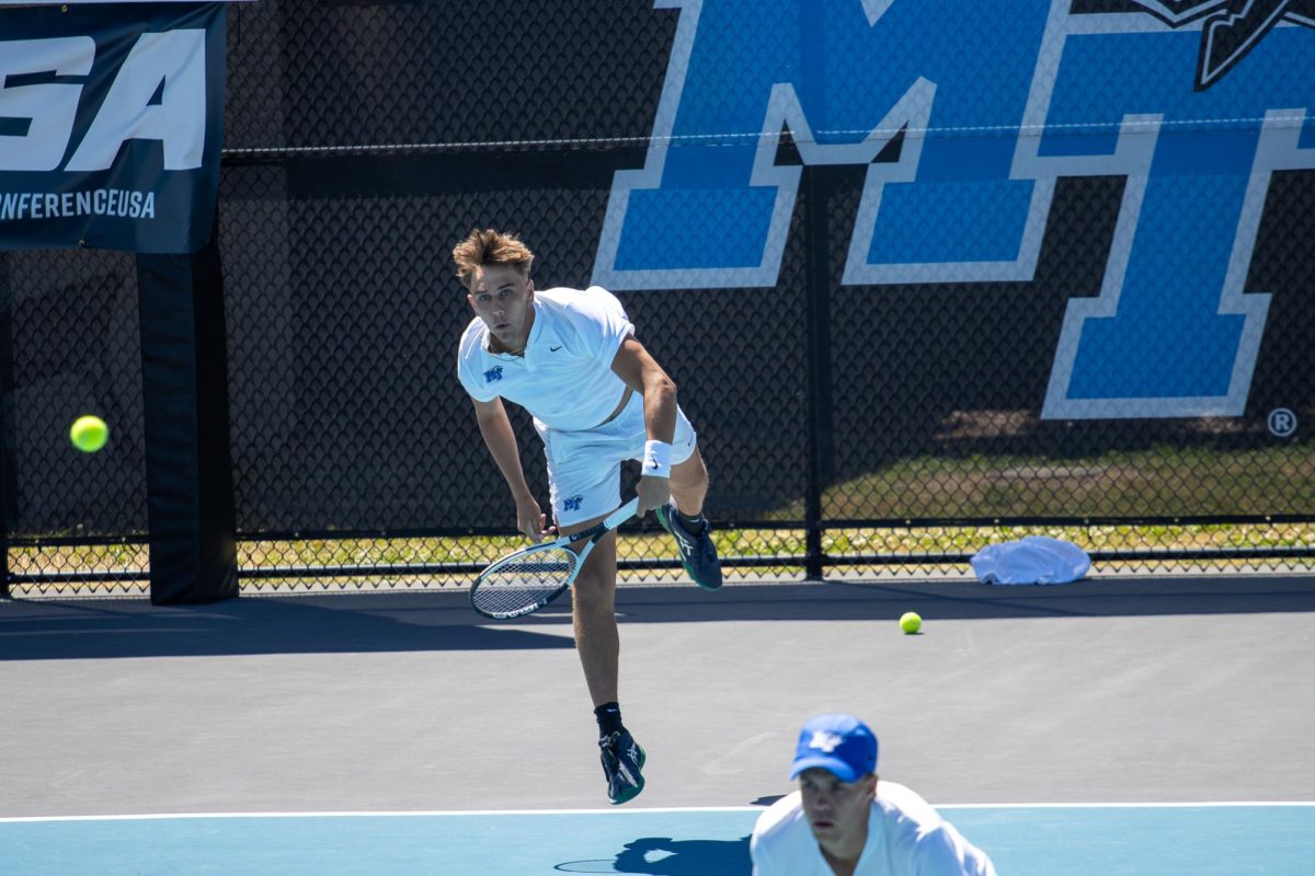 Eric Crevei (left) serves while partner Jonasz Dziopak stands in front during the CUSA men's tennis championships against Liberty University at the Outdoor Tennis Complex on April 19, 2026. 