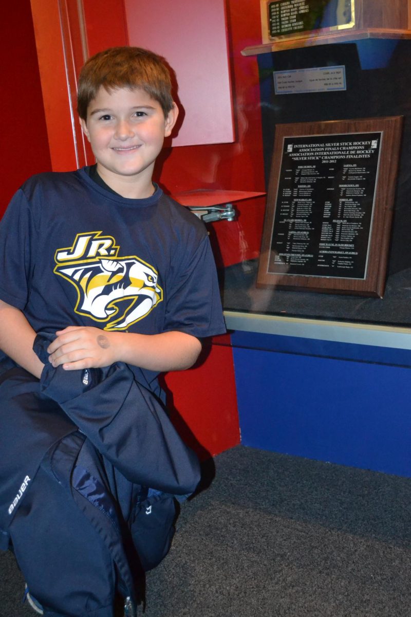 Linden Palmer poses with a plaque with the Jr. Predators championship on it. 