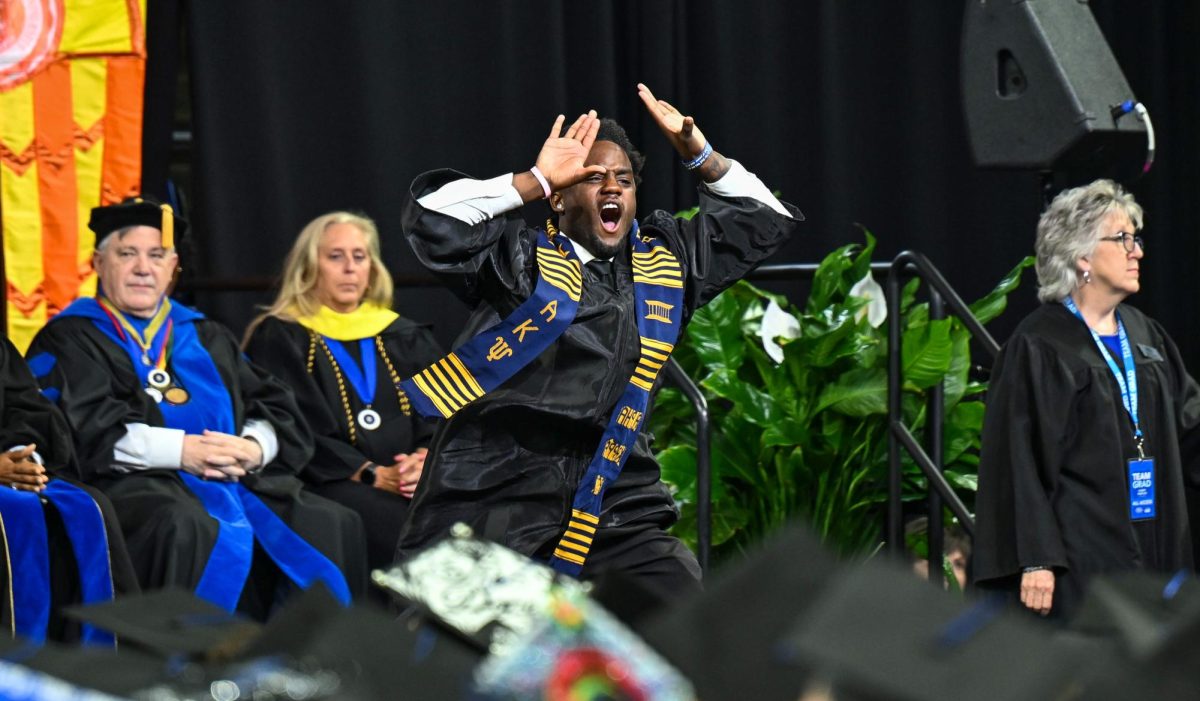 MTSU graduate Andrew Scharkley dances while on stage during spring commencement inside the Murphy Center on May 9, 2026.
