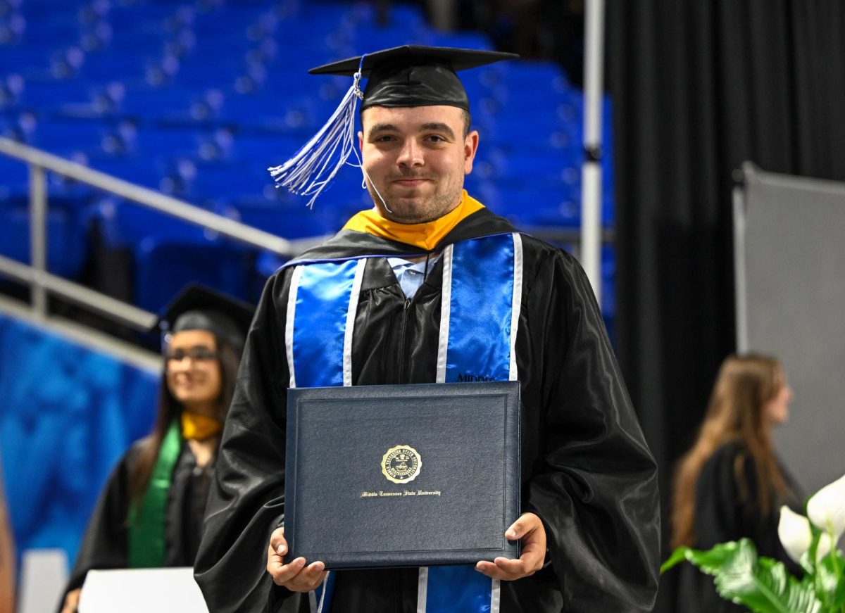 MTSU graduate Griffin Brunner poses for a picture after receiving his diploma during spring commencement inside the Murphy Center on May 9, 2026.