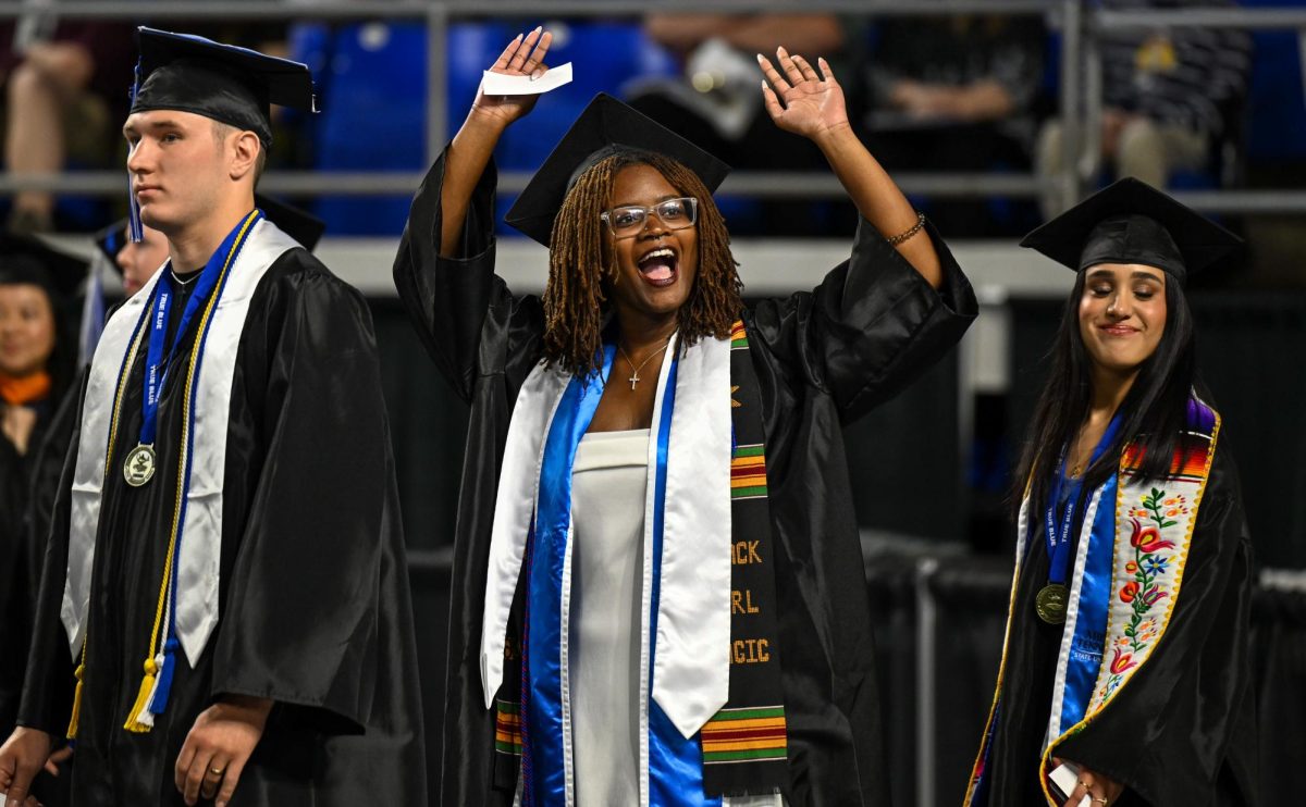 MTSU graduate Tania Humphrey waves to family and friends during spring commencement inside the Murphy Center on May 9, 2026.