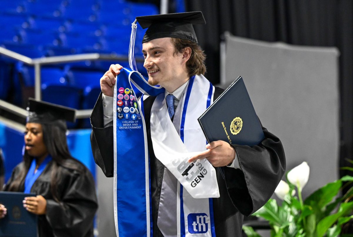 MTSU graduate Ethan Williams poses for a picture after walking across the stage during spring commencement inside the Murphy Center on May 9, 2026.