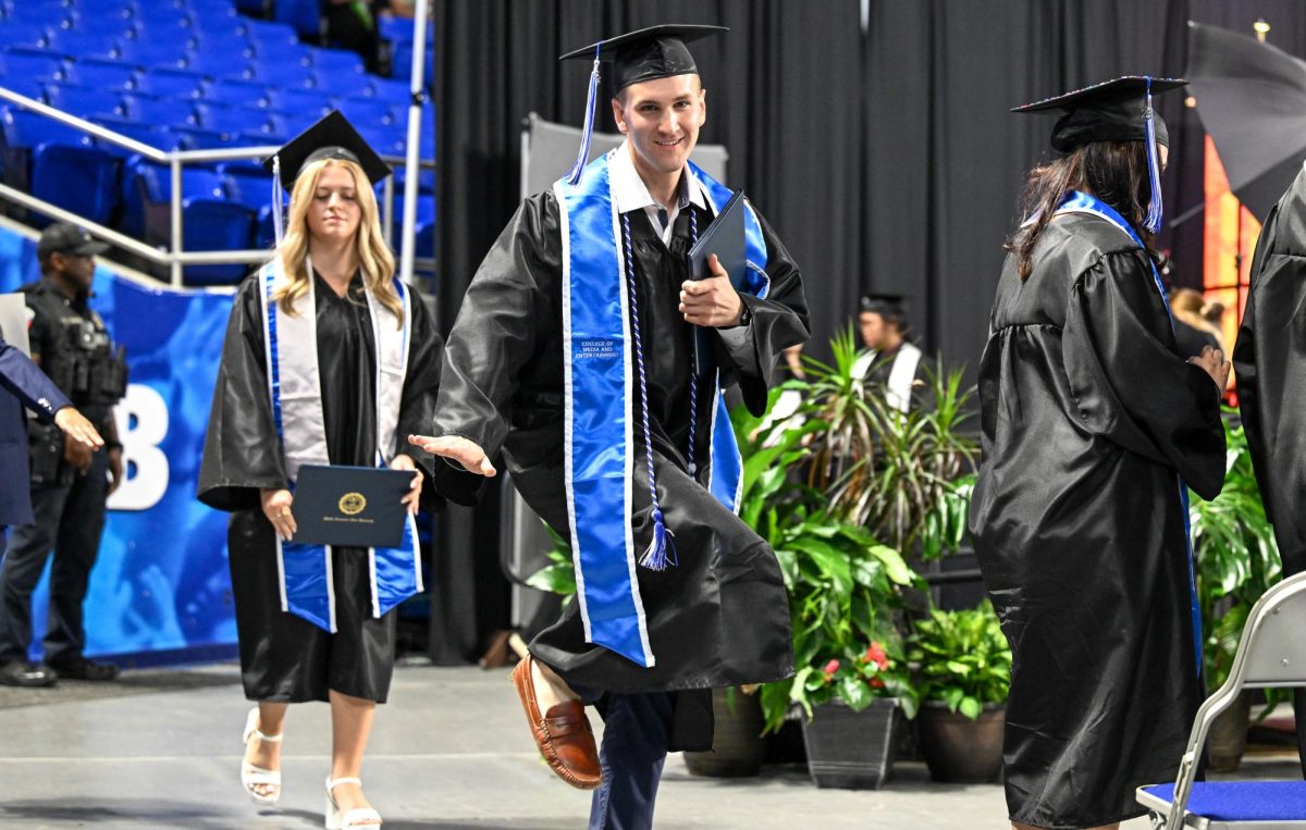 MTSU graduate Connor Smith hits the Heisman pose during spring commencement inside the Murphy Center on May 9, 2026.