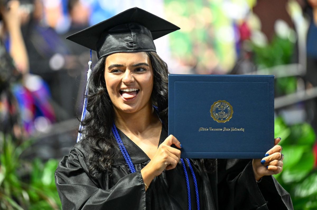 MTSU graduate Sayra Garcia holds her diploma after walking across the stage during spring commencement inside the Murphy Center on May 9, 2026.