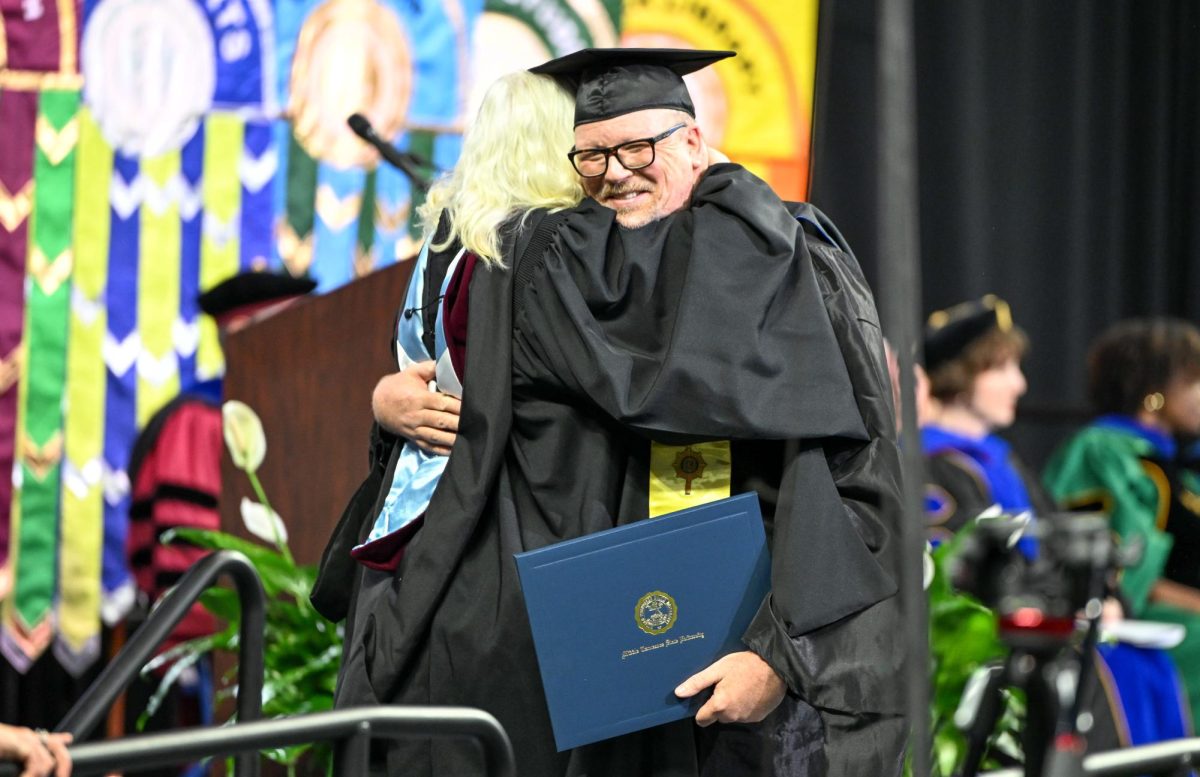 MTSU Master of Science graduate Brian Maxwell (right) hugs dean of the College of Media and Entertainment Beverly Keel (left) during spring commencement inside the Murphy Center on May 9, 2026.