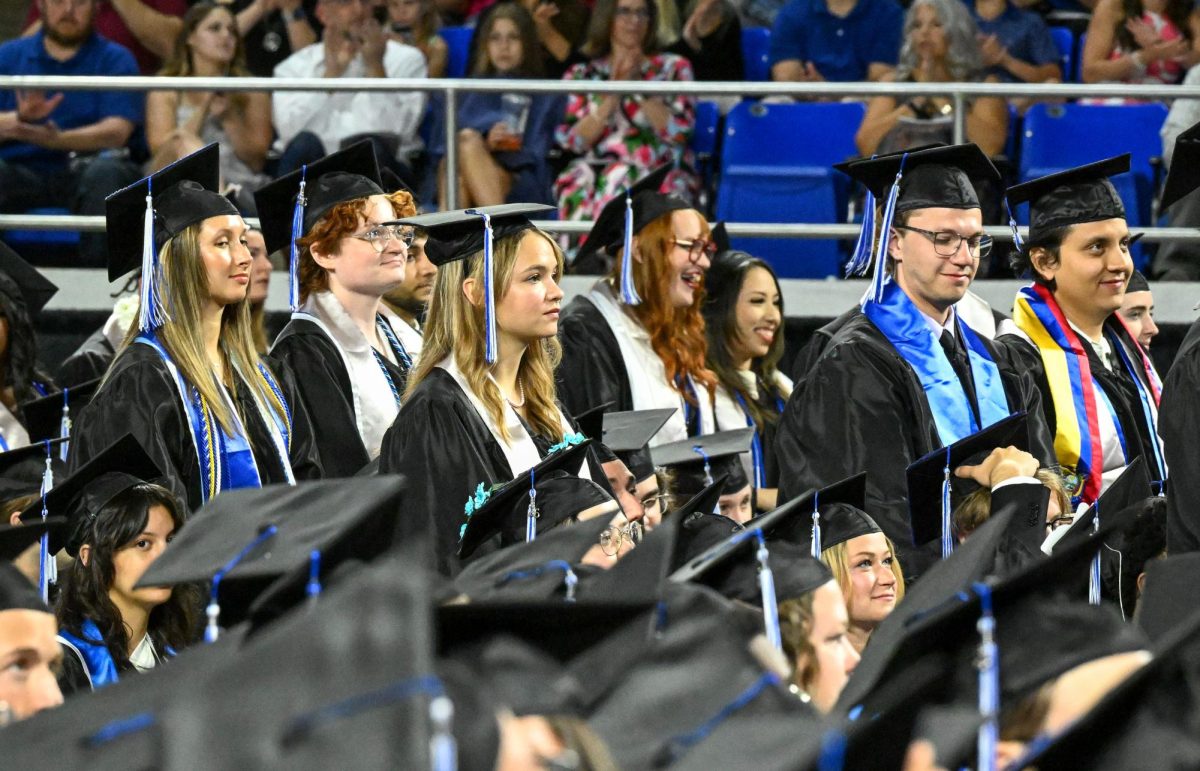 Graduates stand to be recognized for academic distinction during spring commencement inside the Murphy Center on May 9, 2026.