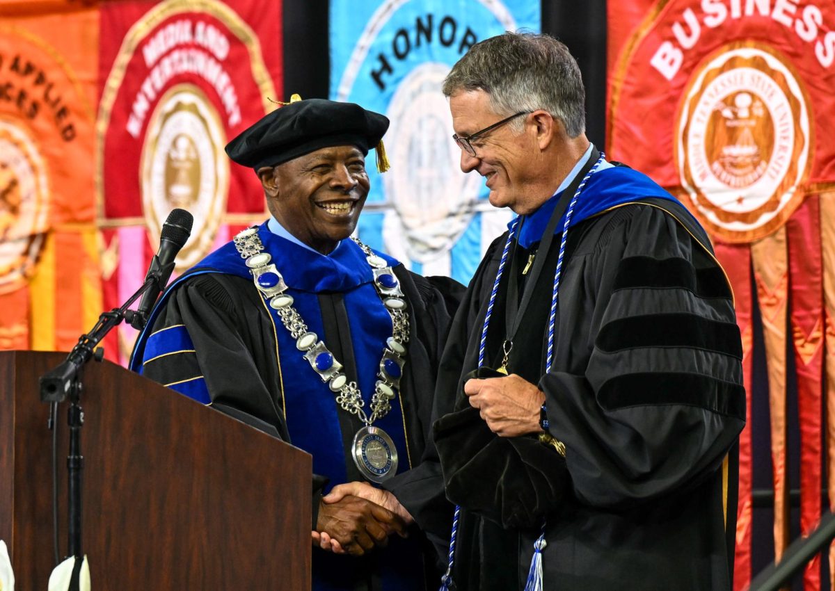 MTSU president Sidney A. Mcphee (left) and MTSU provost Mark Byrnes (right) shake hands during spring commencement inside the Murphy Center on May 9, 2026.