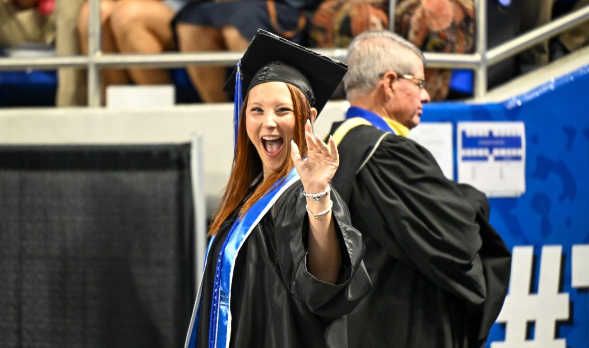 MTSU Sidelines Multimedia Editor Caitlyn Hajek waves during spring commencement inside the Murphy Center on May 9, 2026.