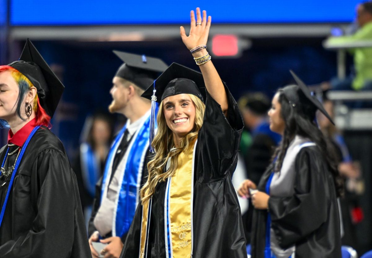MTSU graduate Josie Knight waves to family and friends during spring commencement inside the Murphy Center on May 9, 2026.