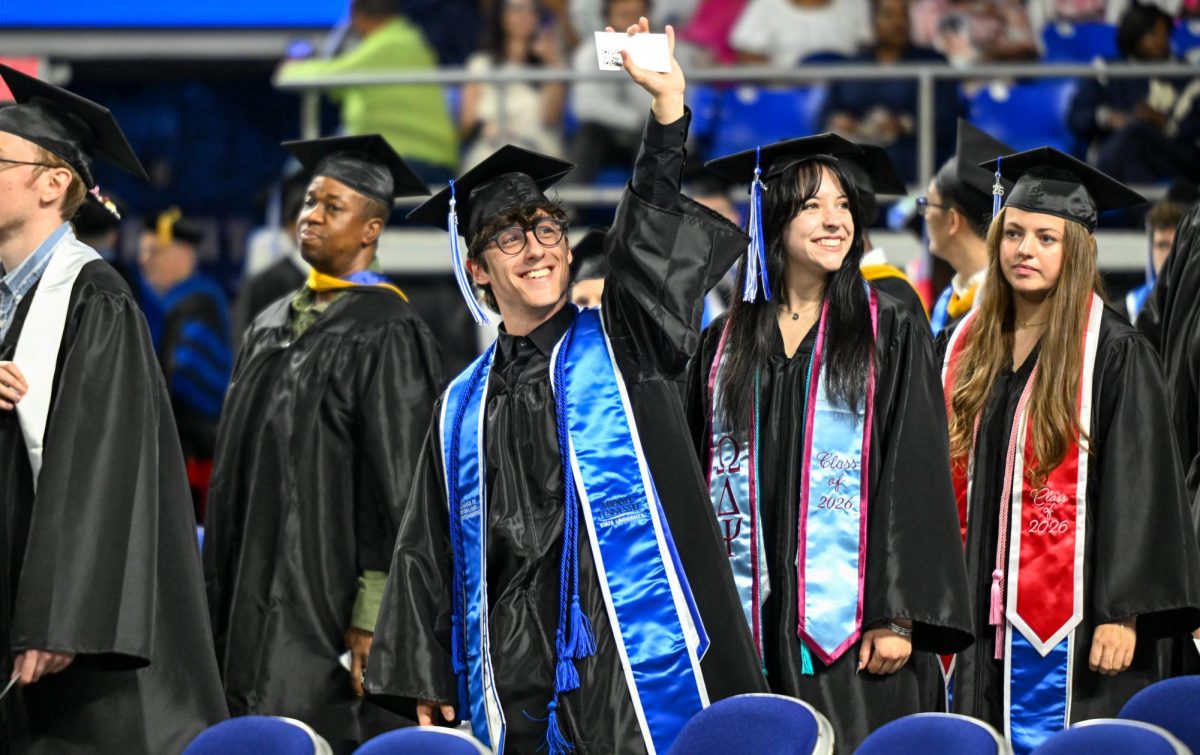 Graduates walk down the middle aisle during spring commencement inside the Murphy Center on May 9, 2026.