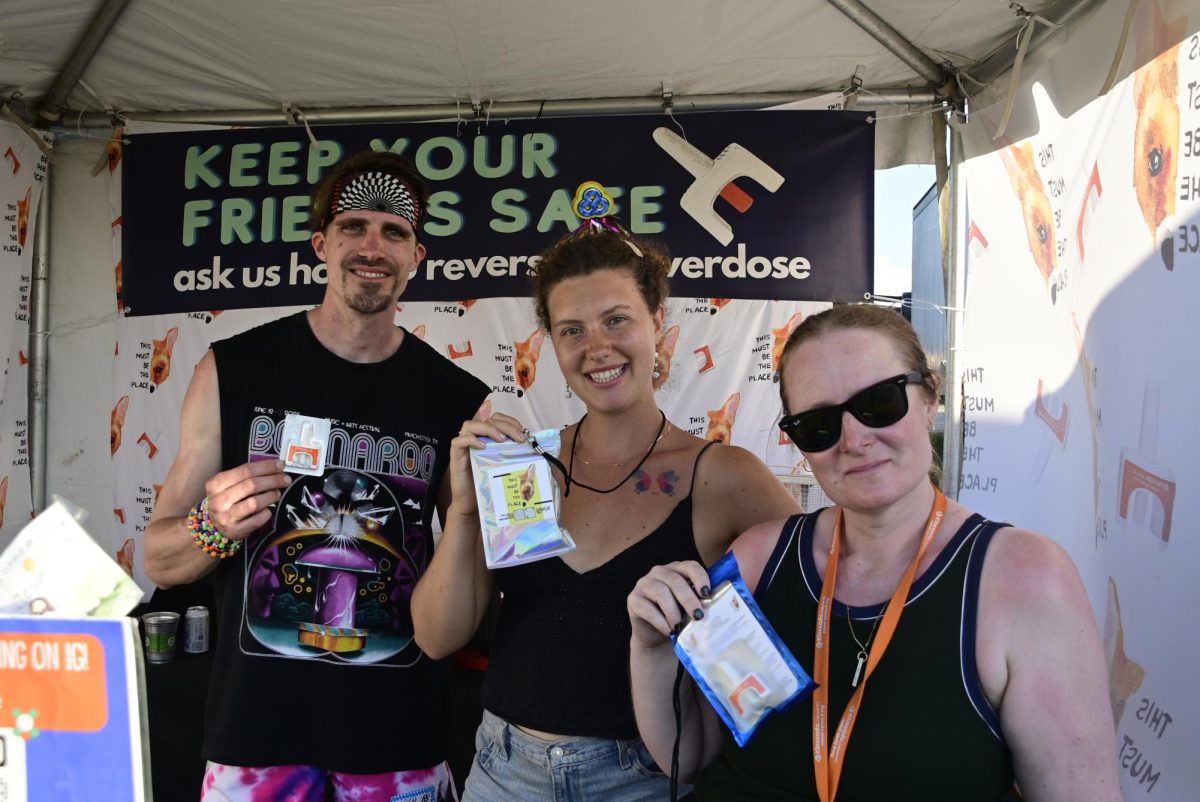 Josh Mass, Maya Land and Ingela Travers-Howard hold up naloxone at Bonnaroo Music & Arts Festival in Manchester, Tennessee, on June 11, 2026.