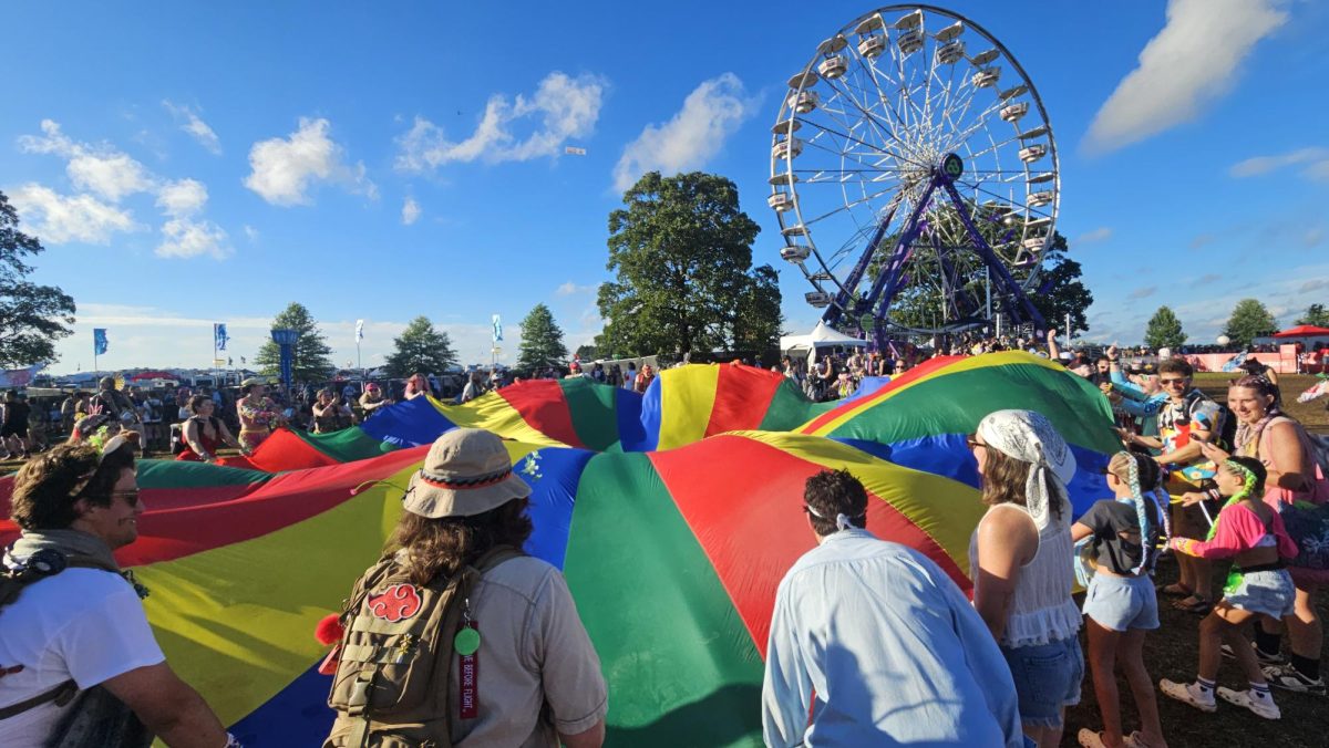Festival-goers gather by The Other Stage with a giant rainbow playground parachute at Bonnaroo Music & Arts Festival in Manchester, Tennessee on June 14, 2026,